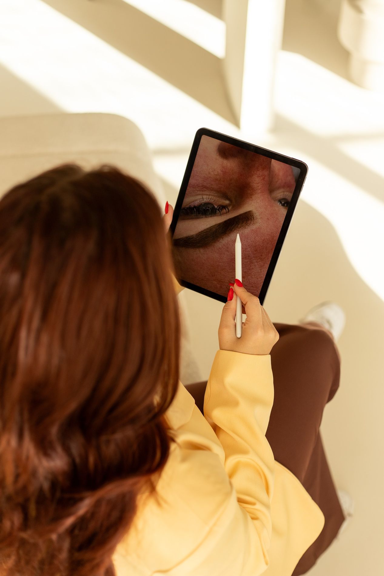 Cheyenne met een tablet waarop een wenkbrauwontwerp staat